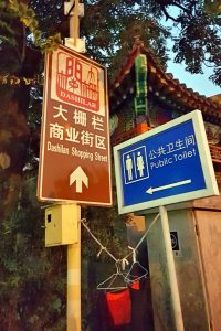 Cartel indicador de baños públicos en Beijing